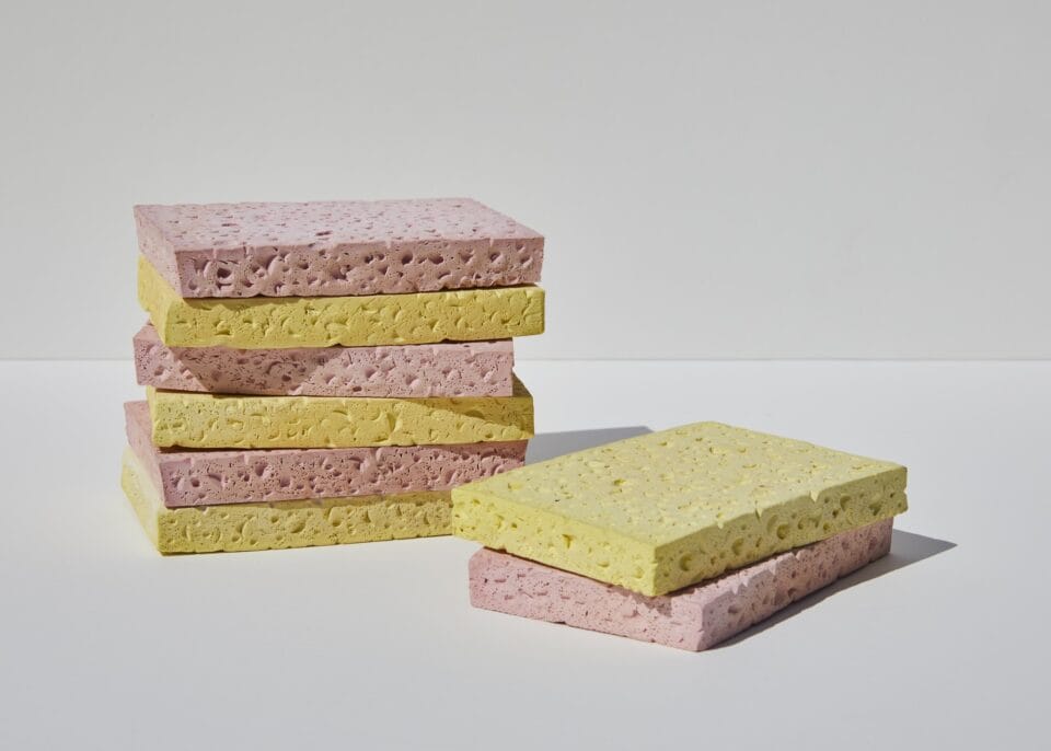 a ceramic sculpture of two piles of yellow and pink cleaning sponges