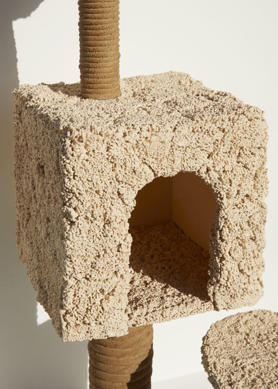 detail of a ceramic sculpture of a cat scratching tower