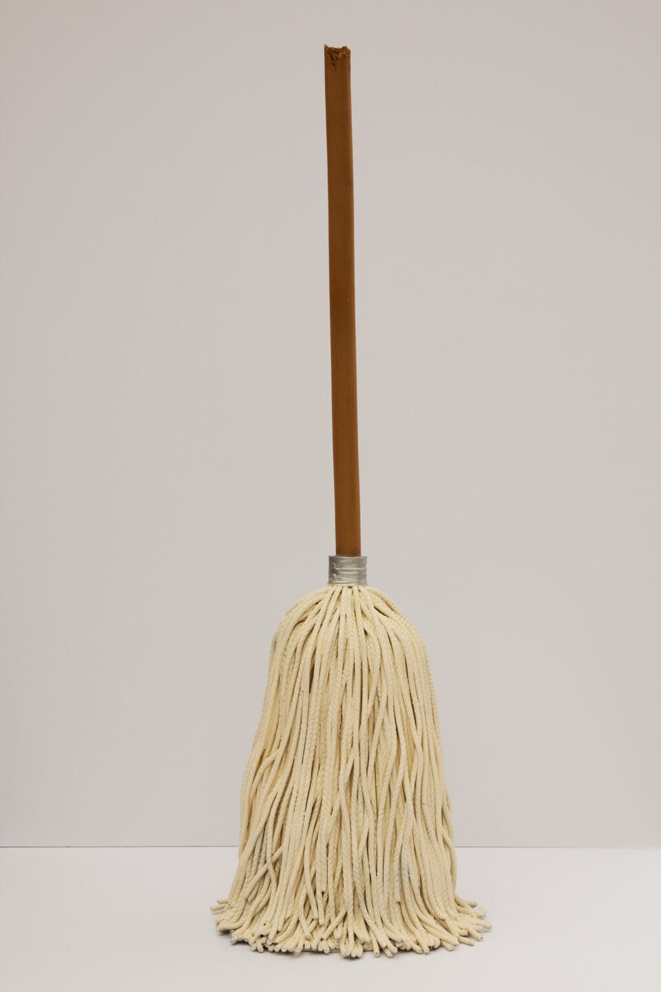 a ceramic sculpture of a broom standing upright