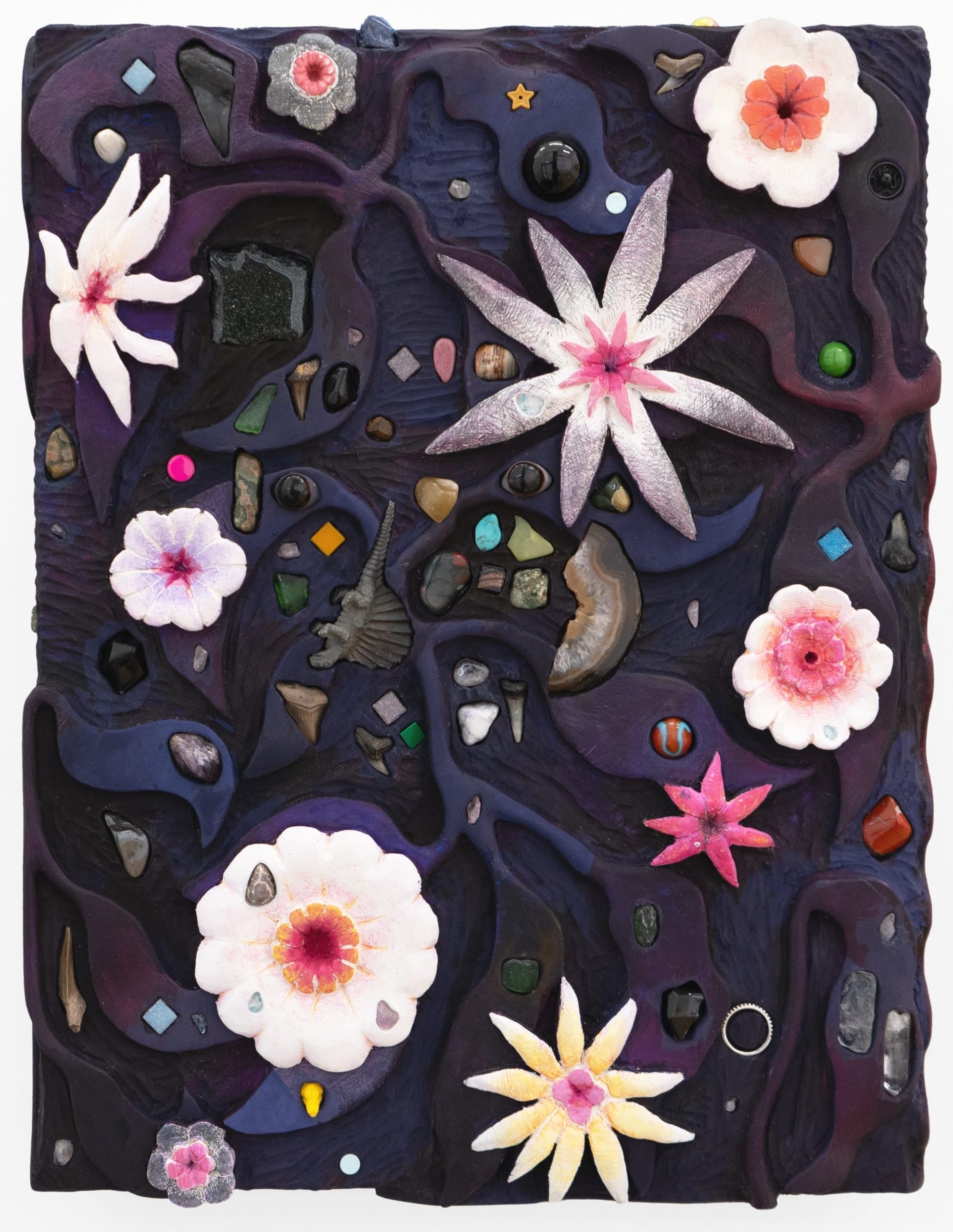 pink flowers, stones, shells, and more are embedded in a deep purple sculptural painting