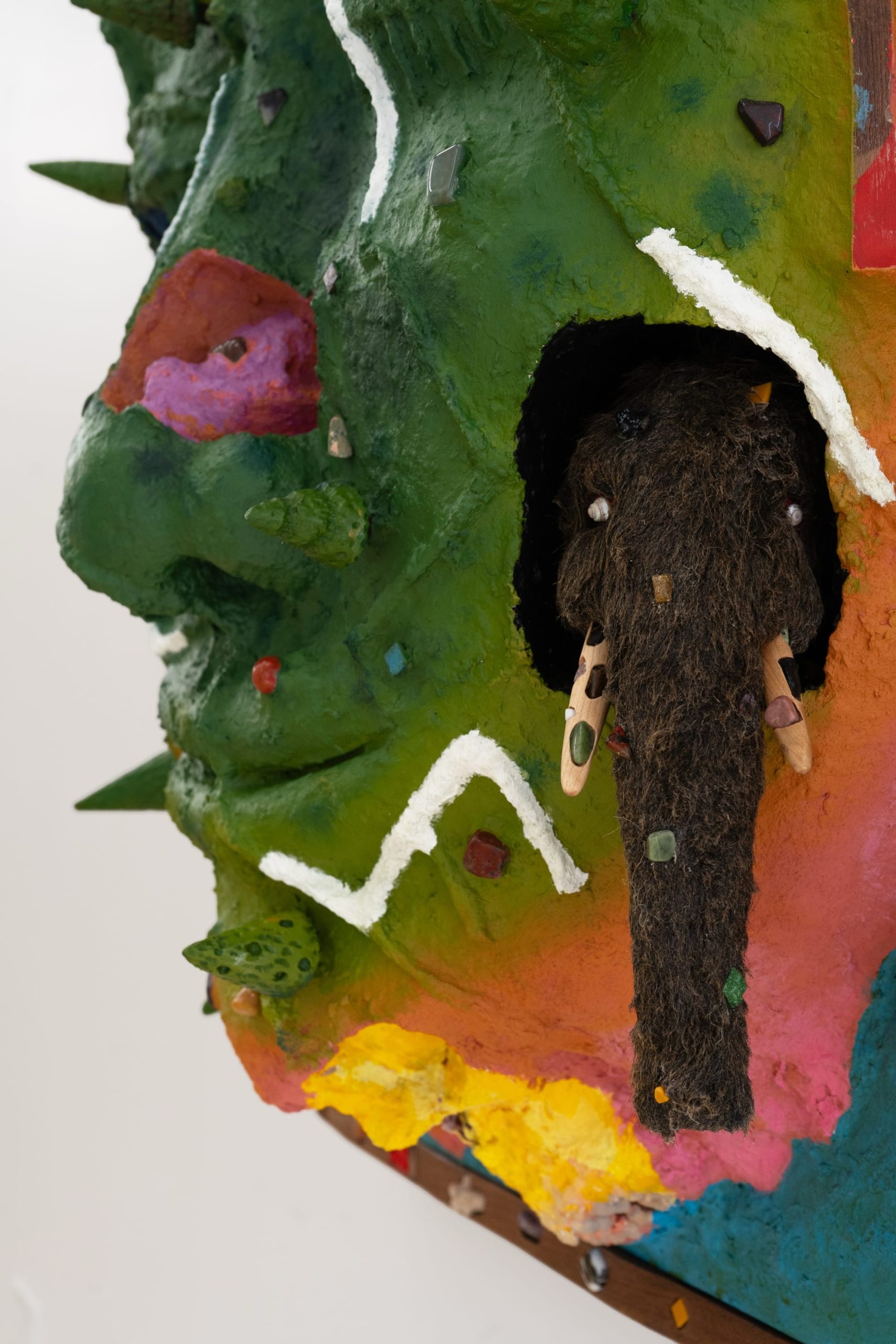 a wooly mammoth embedded into a sculptural painting shaped like a face