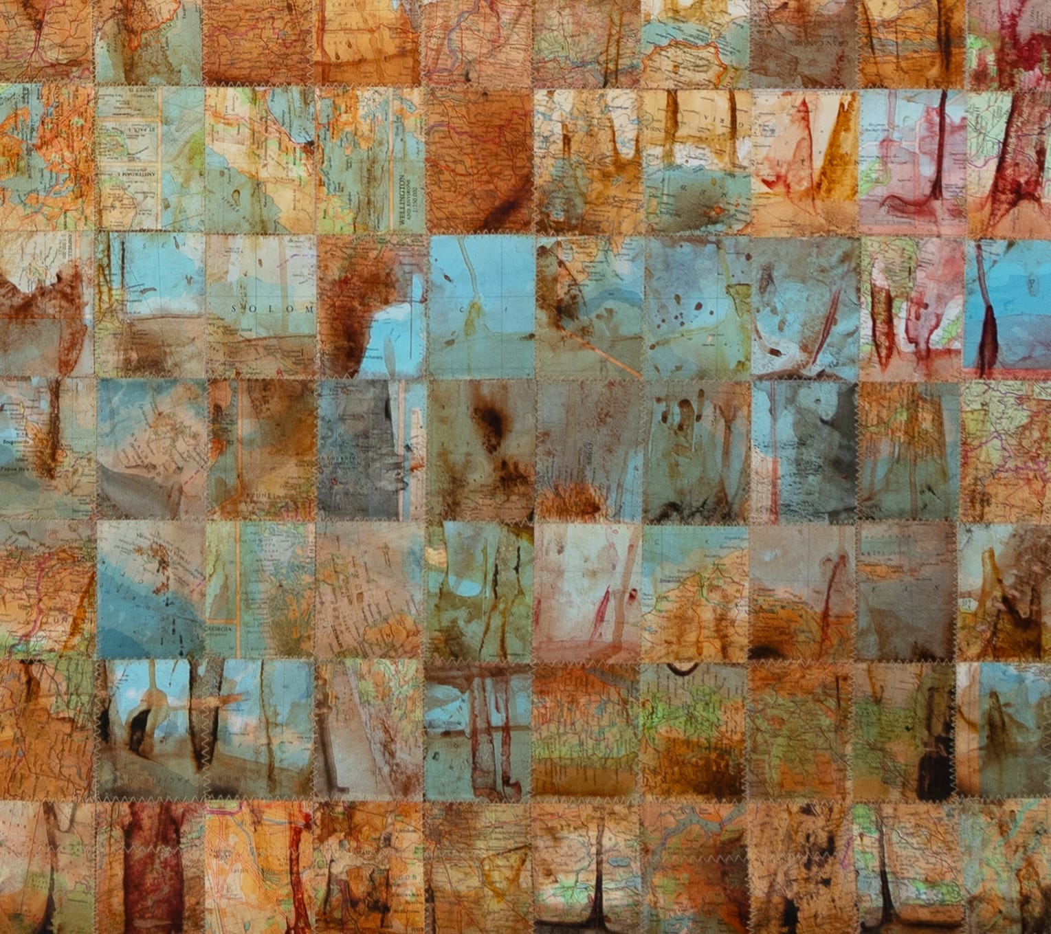 a detail of an artwork made from maps that have been deconstructed and reassembled into a grid pattern