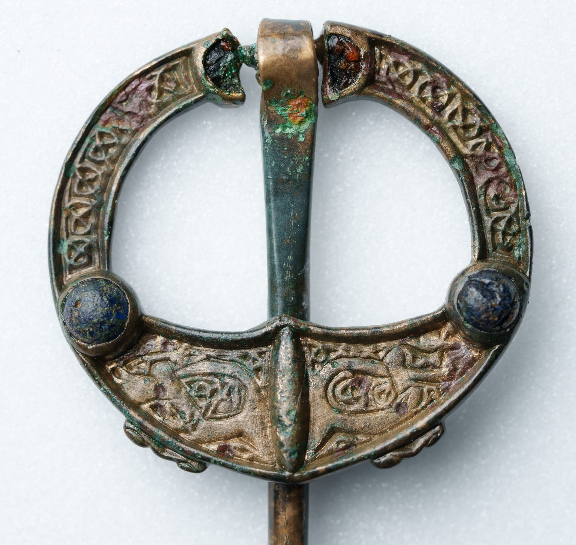 an early medieval brooch-pin with ornate metalwork and precious stones