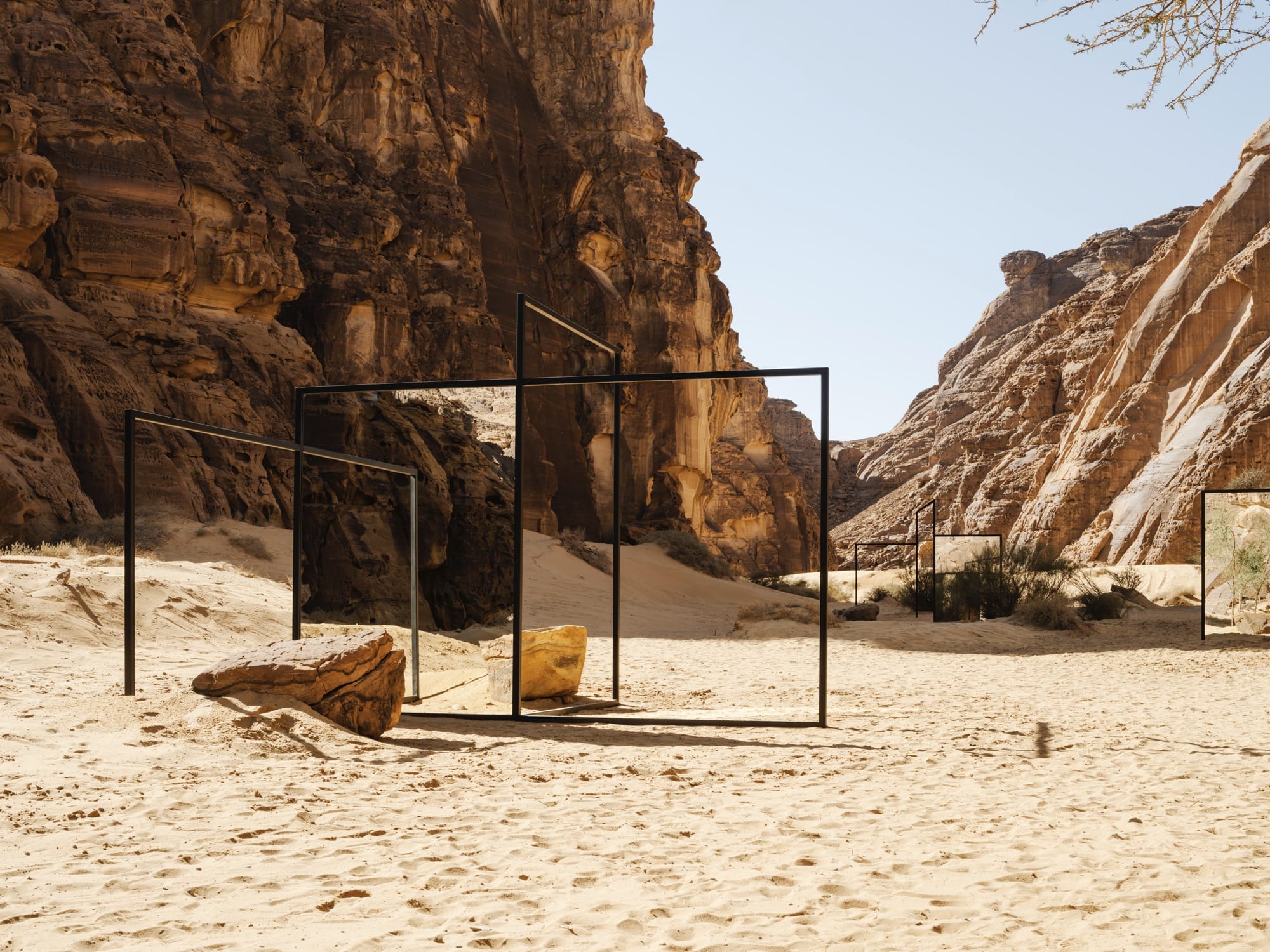 mirror panels in a desert with stones surrounding it