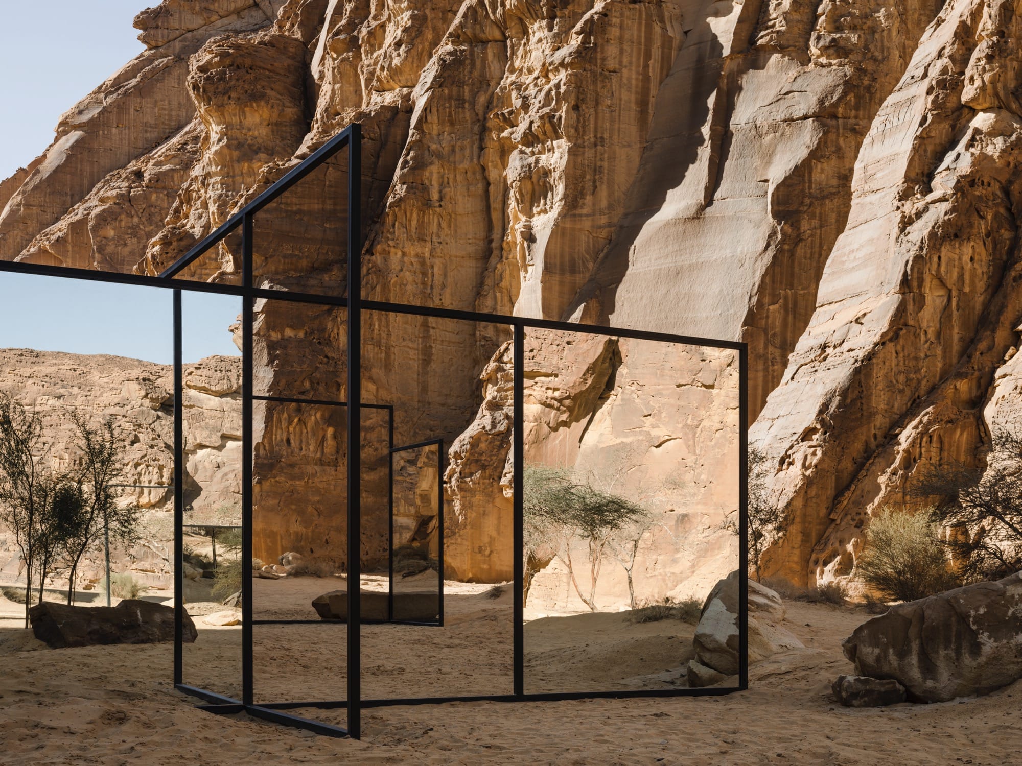 mirror panels in a desert with stones surrounding it