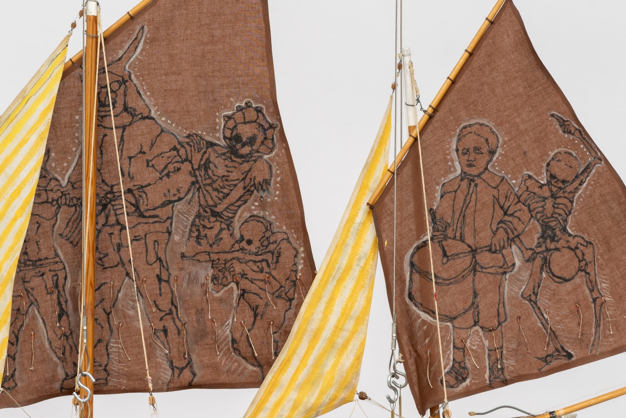 detail of a sculpture of ship sails with drawings of people dancing with skeletons