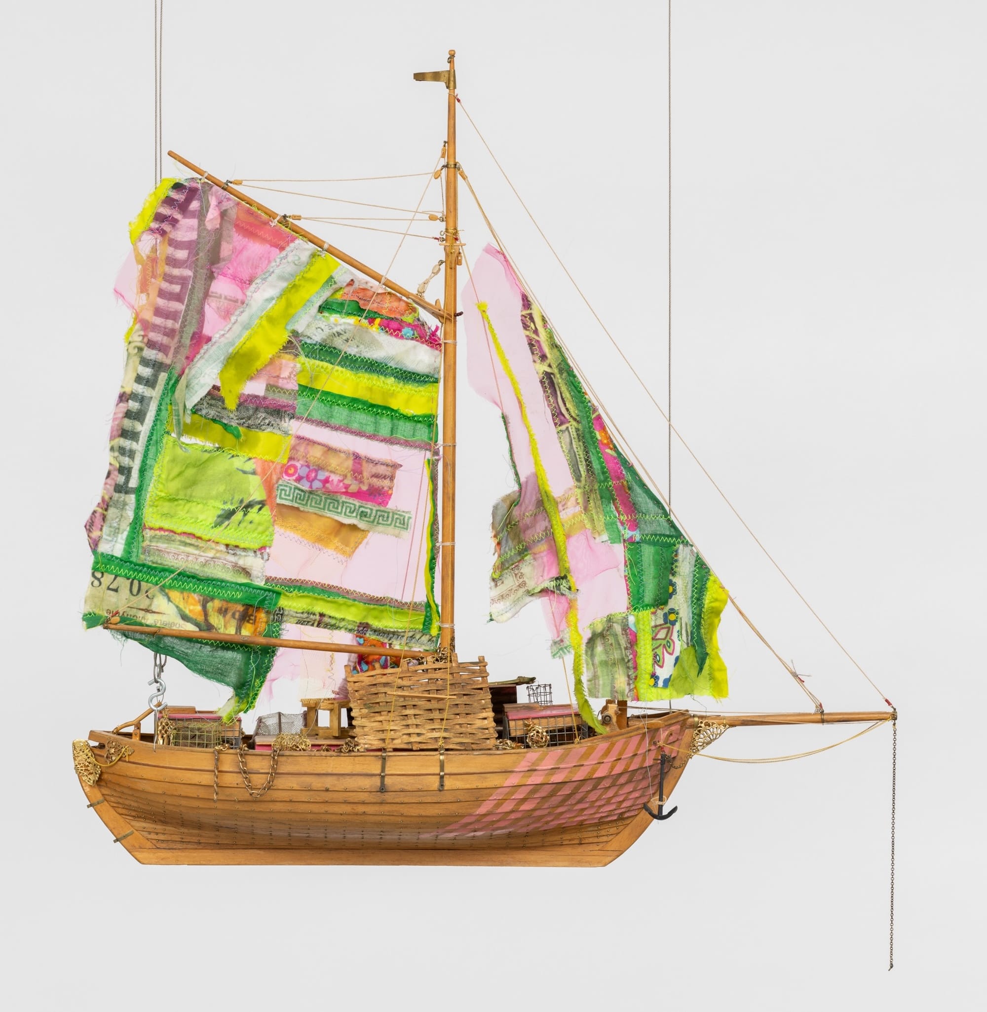a sculpture of a boat with large, colorful, patchwork sails