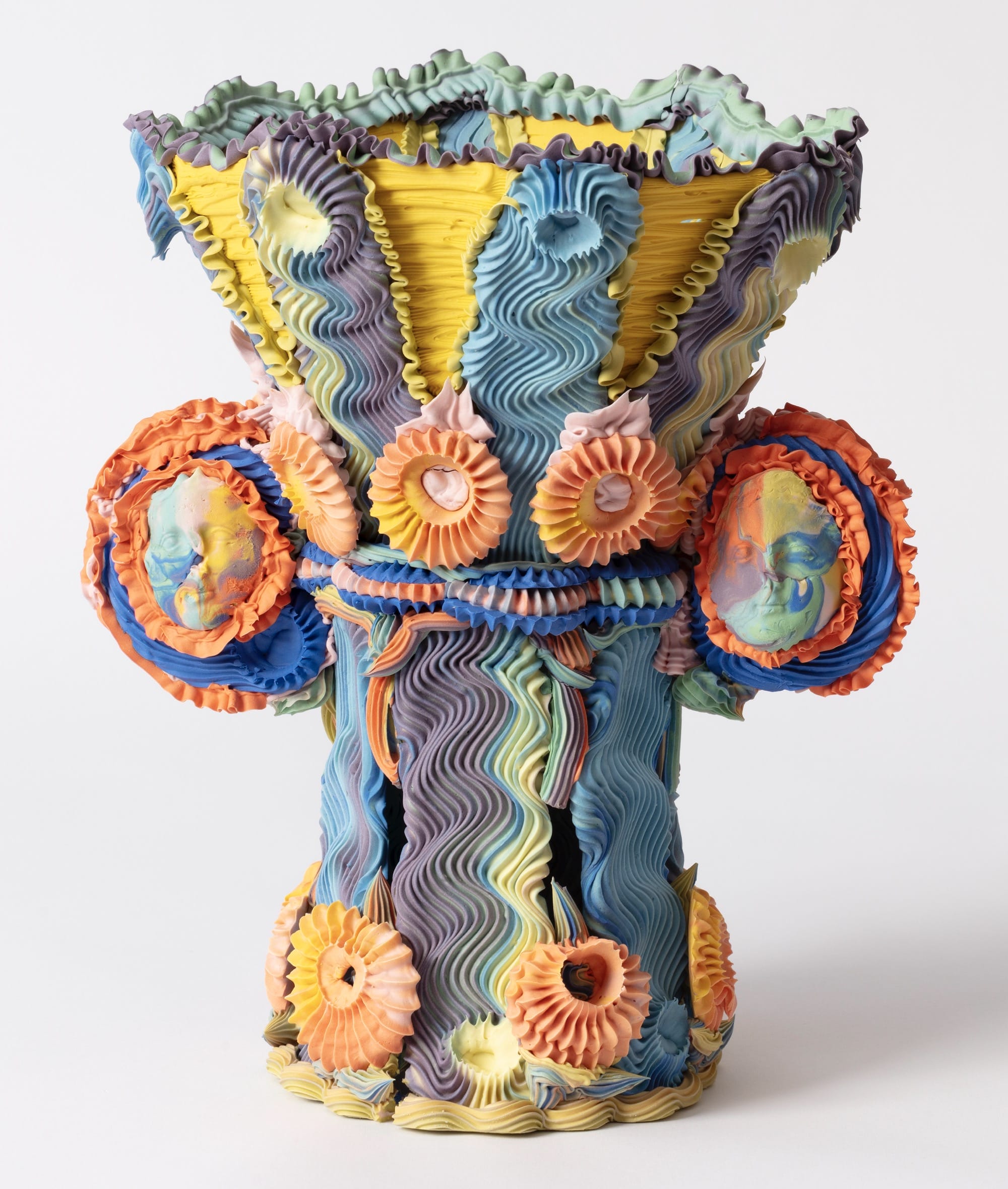 an elaborate, multi-colored ceramic vase made with clay piped like frosting