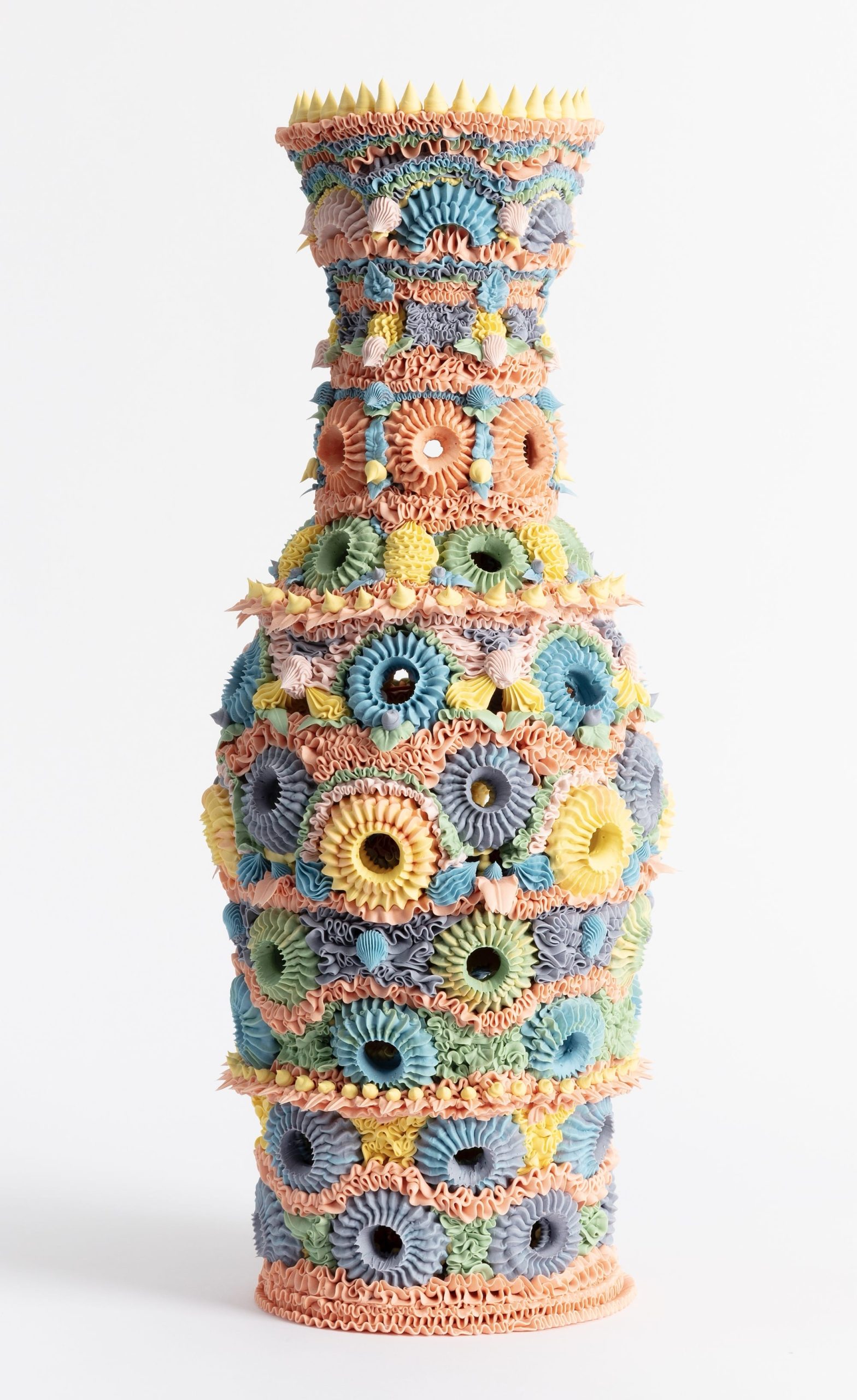 an elaborate, multi-colored ceramic vase made with clay piped like frosting
