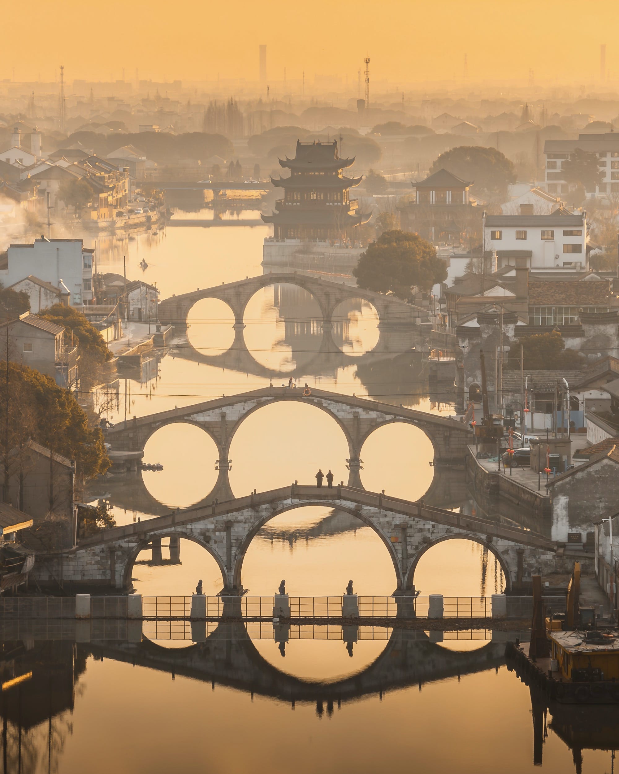a hazy, yellow image of three bridges in a city