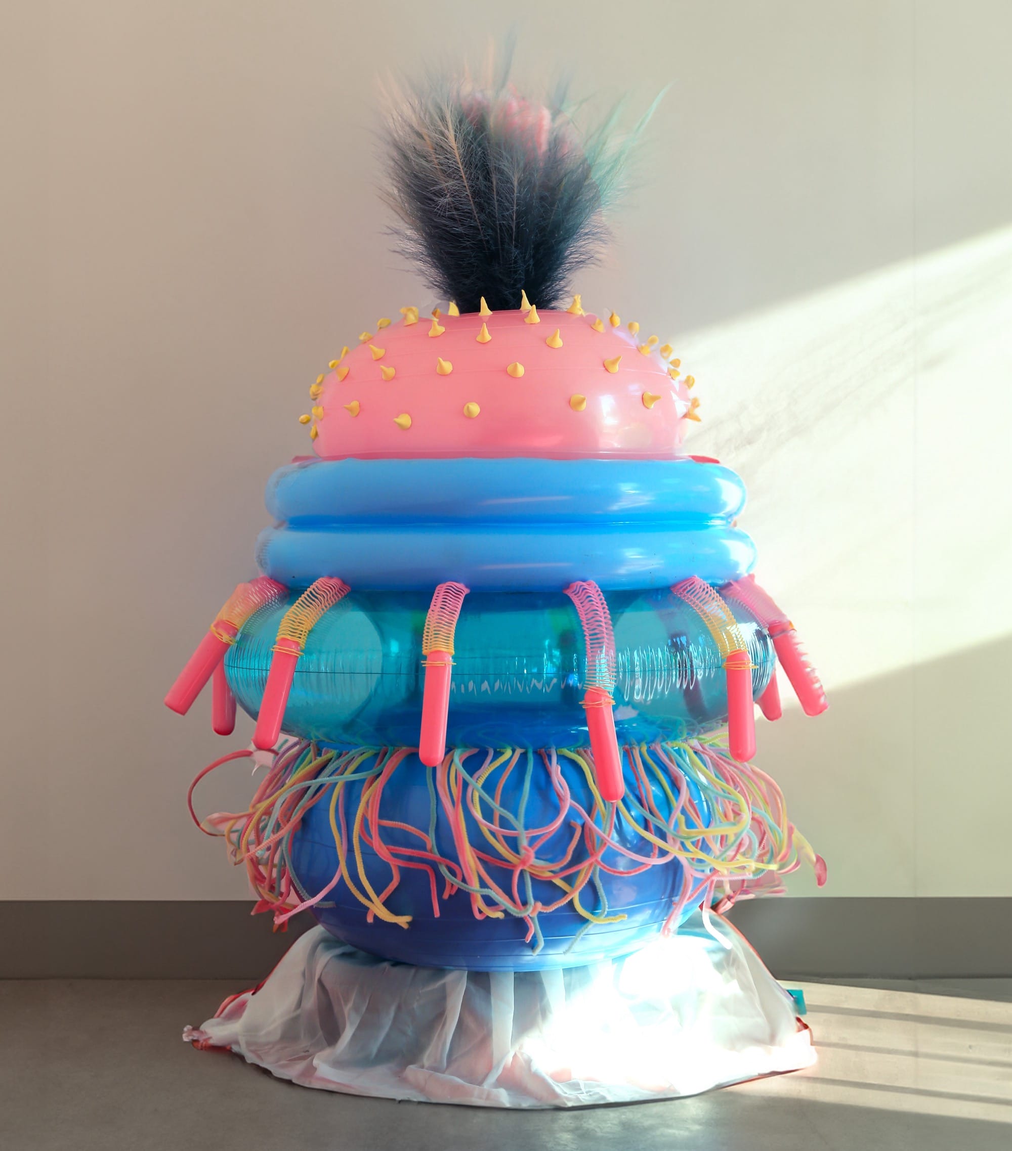 an abstract inflatable artwork that resembles a pink and blue, alien-like creature