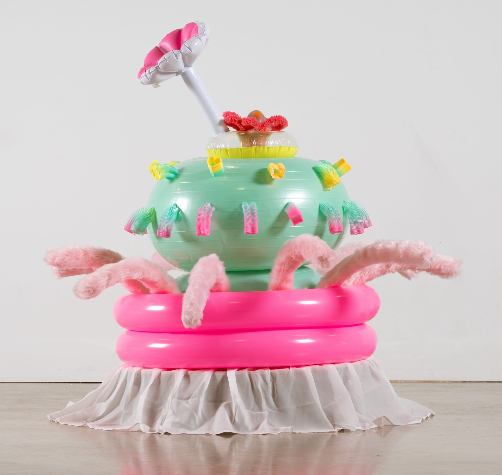an abstract inflatable artwork that resembles a pink and green, alien-like creature