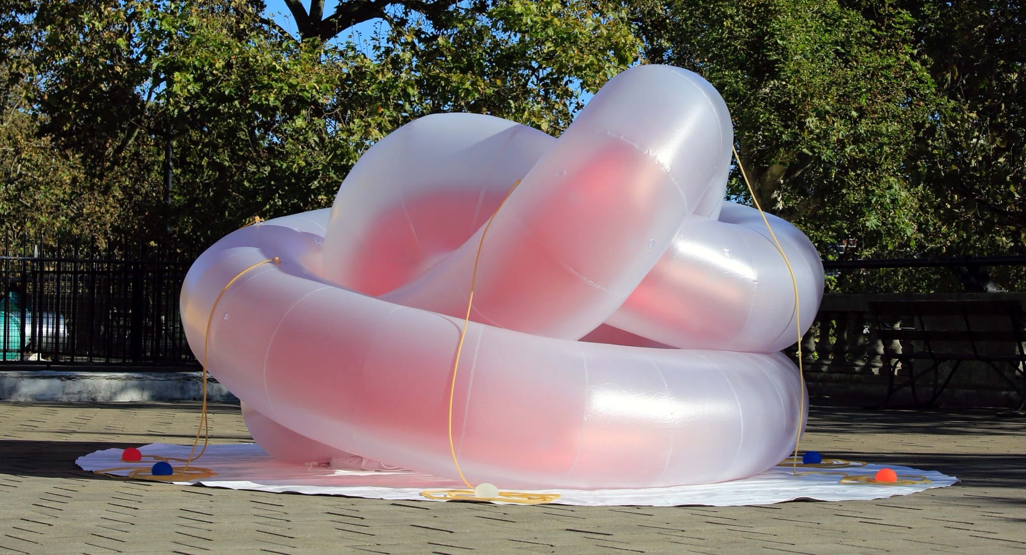 an abstract inflatable artwork that resembles a pink, alien-like creature outside
