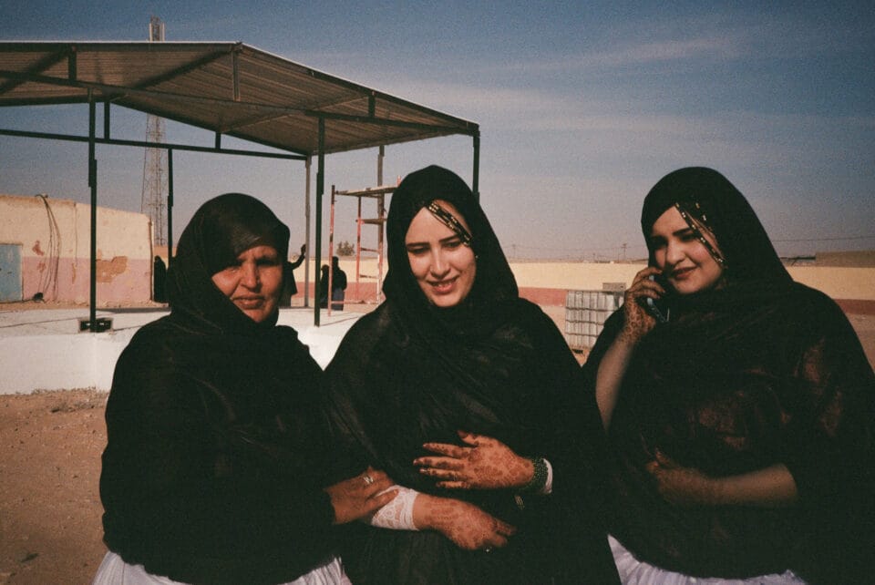 a portrait of three Sahrawi women in the desert