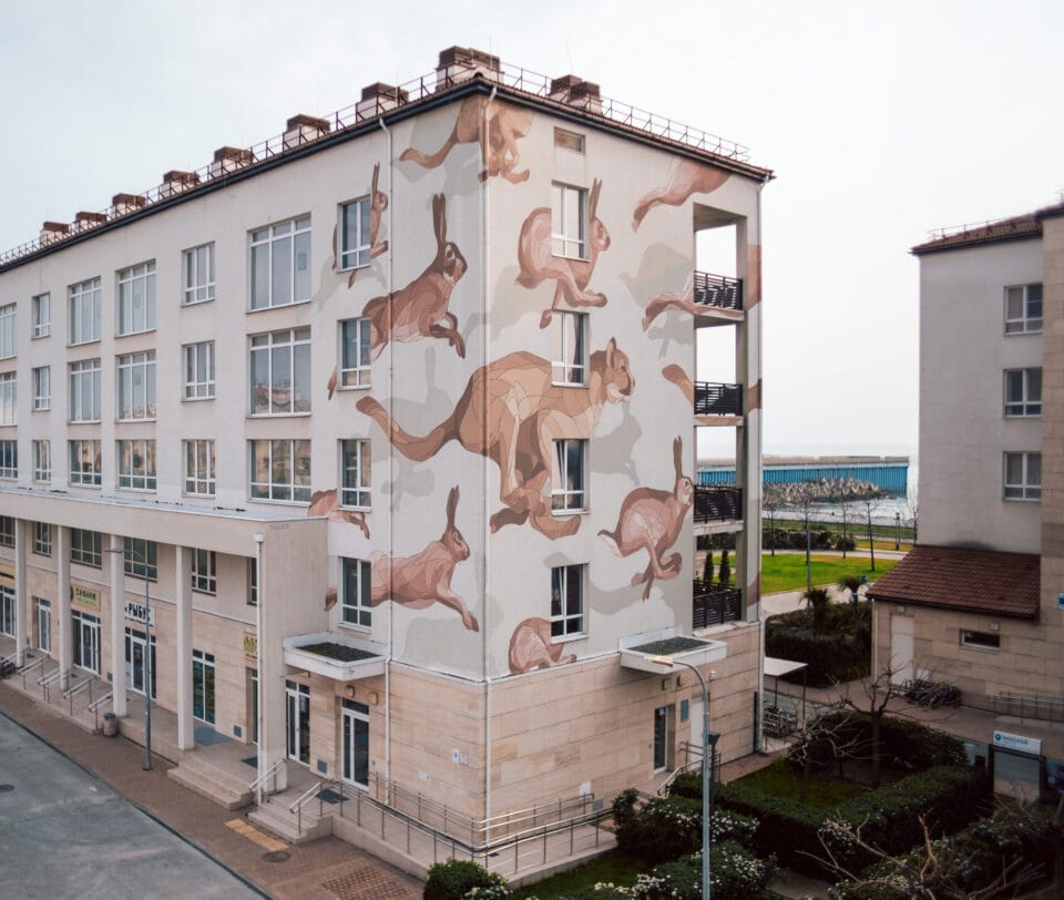 a mural of running animals on the side of a building