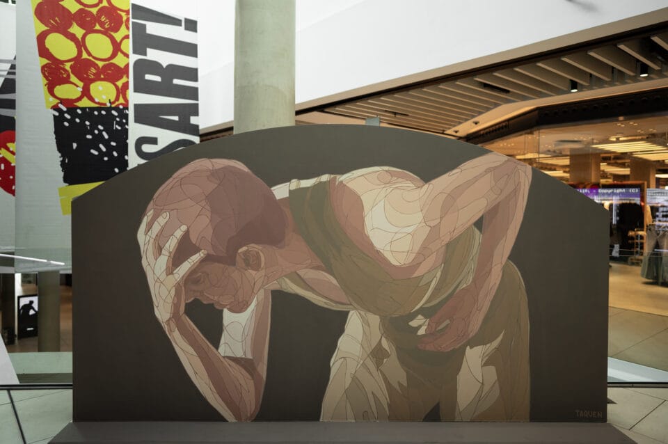 a large work inside of a shopping center depicting a dancing figure